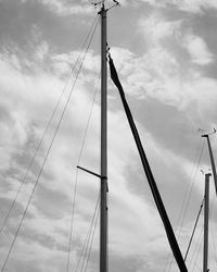 Low angle view of electricity pylon against cloudy sky