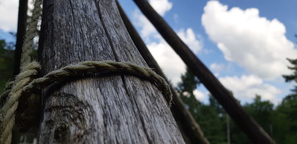 Low angle view of wooden post against sky