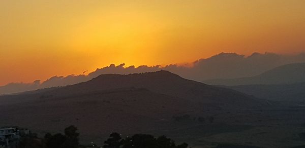 Scenic view of silhouette mountains against sky during sunset