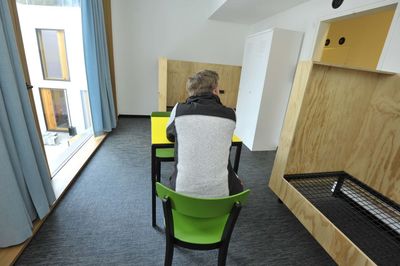 Rear view of woman sitting on chair at home