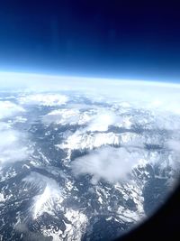 Aerial view of snowcapped mountains and sea against sky