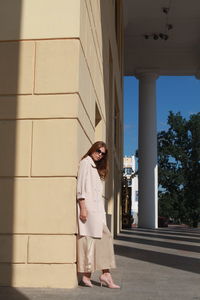 Young female model posing against wall