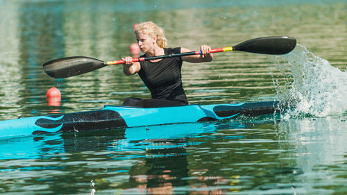 Young woman kayaking on lake