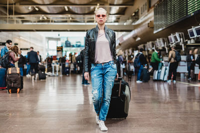 Portrait of young woman standing in city