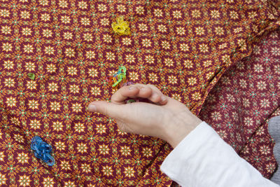 Cropped hand of woman holding plastic at table