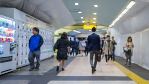 People walking in illuminated underground walkway