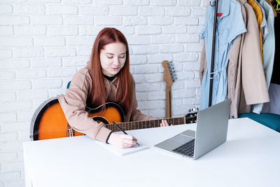 Portrait of young woman using laptop while sitting at home