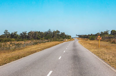 Road passing through landscape against clear sky