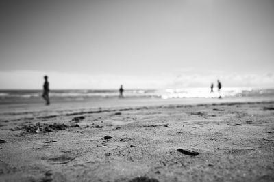 Silhouette people on beach against sky