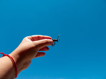 Close-up of hand holding blue sky