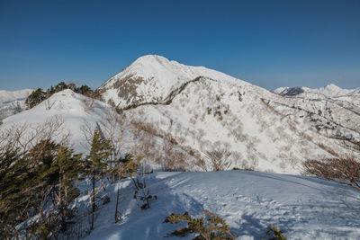 Scenic view of snow covered mountains against clear sky