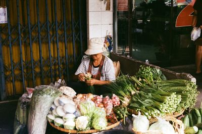 Man with vegetables for sale at market stall