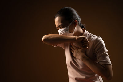 Young man holding woman against black background