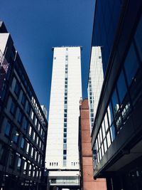 Low angle view of modern buildings against clear blue sky