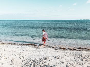 Full length of lady on beach against sky