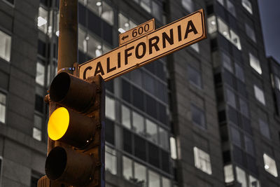 Low angle view of road sign against building in city