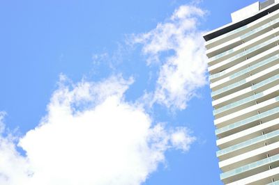 Low angle view of modern building against cloudy sky