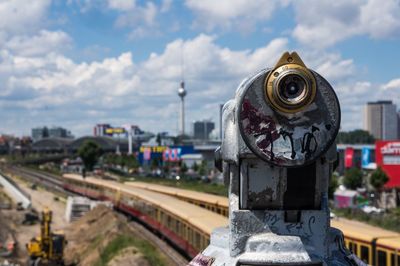 Close-up of binoculars against cloudy sky