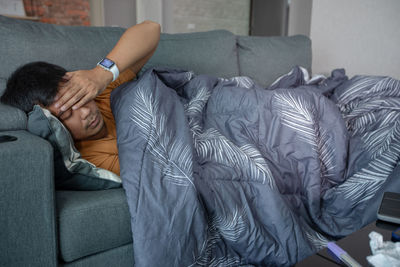 Young man sleeping on sofa at home