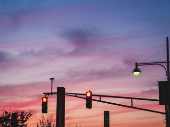 Low angle view of illuminated street light against sky at sunset