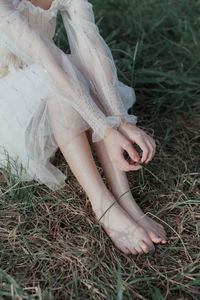 Low section of woman sitting on field