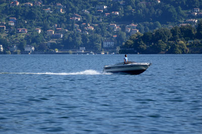 Sailboat sailing on sea by city