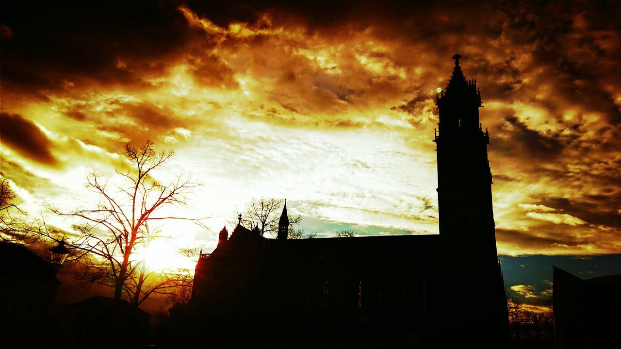 architecture, building exterior, built structure, silhouette, sunset, sky, low angle view, cloud - sky, cloudy, tower, cloud, orange color, tree, dusk, no people, outdoors, dramatic sky, building, tall - high, nature