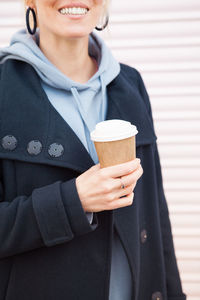 Midsection of woman holding coffee