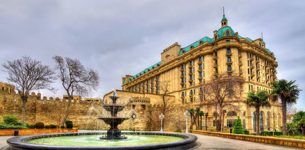 View of fountain building against cloudy sky