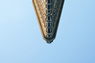 Upside down image of flatiron building against clear sky