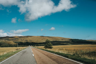 Road passing through landscape against sky