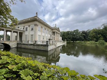 Building by lake against sky