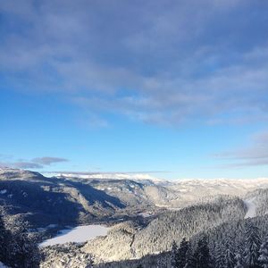 Scenic view of snowcapped mountains against blue sky