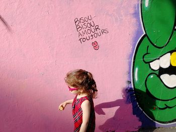 High angle view of woman standing against graffiti wall