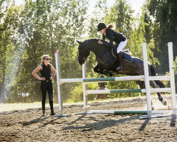 Woman with horse on show jumping course