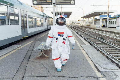 Full length rear view of man standing at railroad station