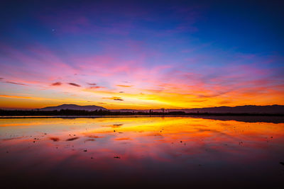 Scenic view of lake against romantic sky at sunset