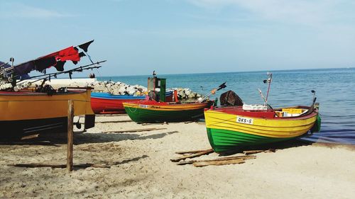 Boats moored on beach against sky