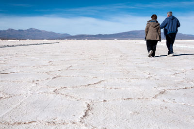 Rear view of people walking on mountain road