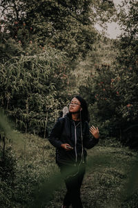 Full length of woman standing in forest