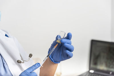 Hands of a doctor preparing a syringe to inject the vaccine for immunization to covid-19 