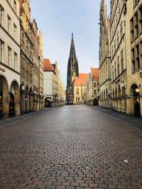 Street amidst buildings against sky in city