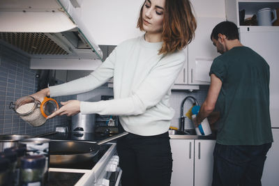 Young roommates preparing food in kitchen