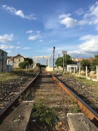 Railroad tracks by buildings against sky