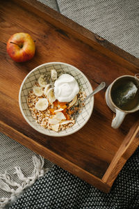 High angle view of breakfast on the couch at home, healthy eating, porridge, apple and tea.