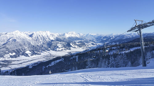 Scenic view of snowcapped mountains against blue sky