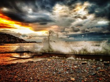 Scenic view of beach against dramatic sky