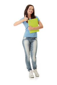 Full length of smiling young woman standing against white background