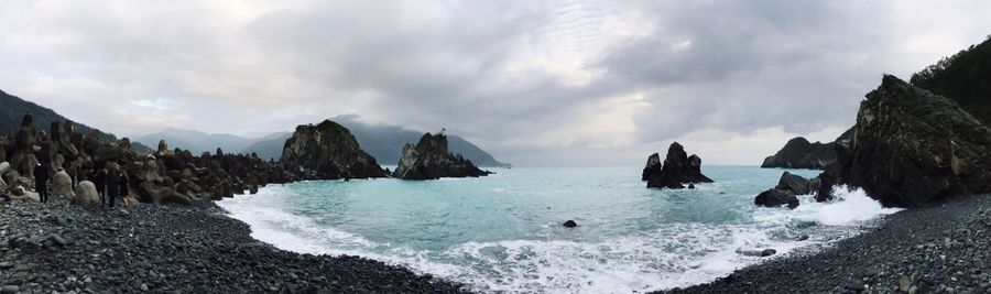 Panoramic view of sea and mountains against sky