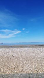 Scenic view of beach against blue sky